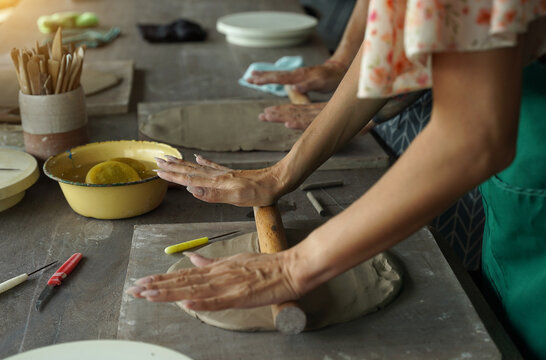 A happy couple makes ceramic plates in a workshop