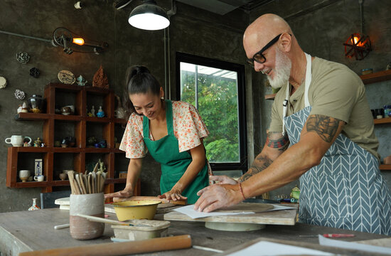 A happy couple makes ceramic plates in a workshop