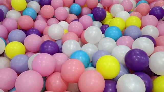 Many colorful plastic balls in a bright ball pit for kids. Suitable for promoting family entertainment centers and childrens play areas.