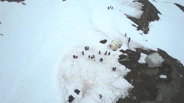 Aerial drone shot of tourists enjoying snow covered mountains with cylindrical buildings and small tents showing the tourists spots in Sissu Ladakh Leh Himachal Pradesh