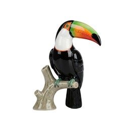 Fototapeta premium Glossy porcelain toucan bird figurine perching on tree branch with large colorful beak