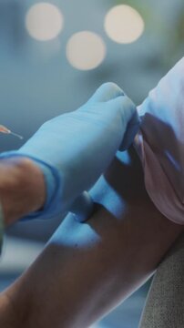 Healthcare professional administering vaccine, Closeup of needle penetrating skin during vaccination