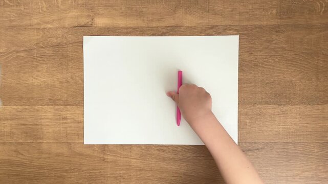 Pink pen being picked up by child hand in slow motion