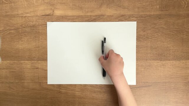 Black pen being picked up and removed from frame by child hand in slow motion