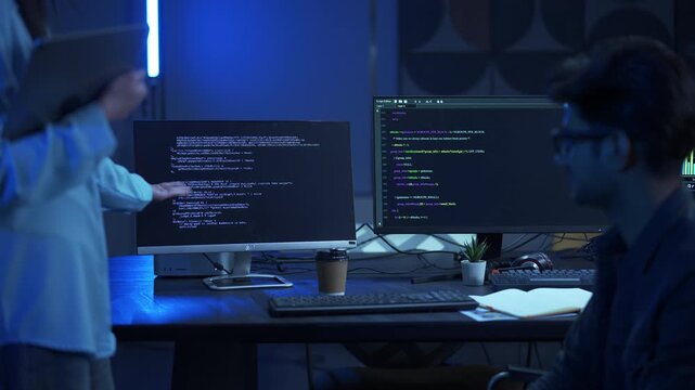 Professional female software developer holding a tablet and presenting system architecture and code development progress to a stakeholder in a modern office.