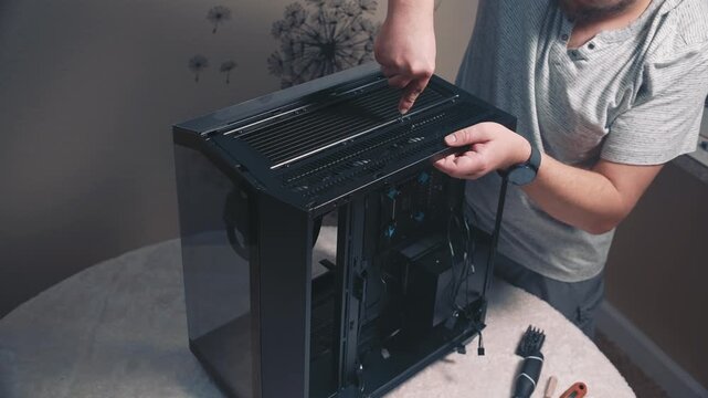 Installing top ventilation panel of computer case with screw fastening using screwdriver during desktop PC assembly