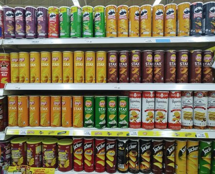 KUALA TERENGGANU MALAYSIA- MAY. 17 2026.."Supermarket shelf with stacked canned potato chips and snacks. Pringles, Lay's Stax, Uncle Saba's, Jacker, and Cottage Fries in assorted flavors."