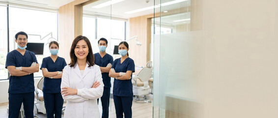 Fototapeta premium Diverse dental team standing in modern clinic with confident female dentist in foreground, smiling healthcare professionals, dental assistants and hygienists, premium medical environment, professional