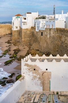 Asilah Medina town wall with waves crashing on the beach in Morocco