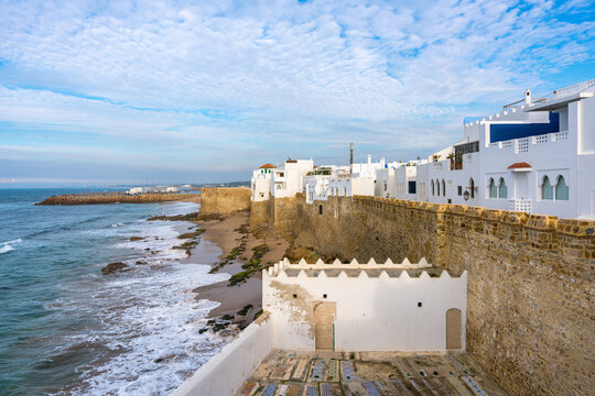Asilah Medina town wall with waves crashing on the beach in Morocco