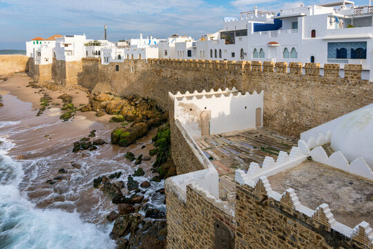 Asilah Medina town wall with waves crashing on the beach in Morocco