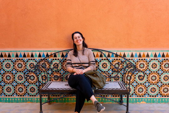 Smiling woman relaxing on an ornate mosaic bench