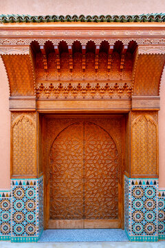 Ornate carved wooden Moroccan door with mosaic tiles in Marrakesh