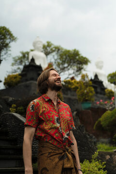 Joyful bearded man laughing at Balinese temple