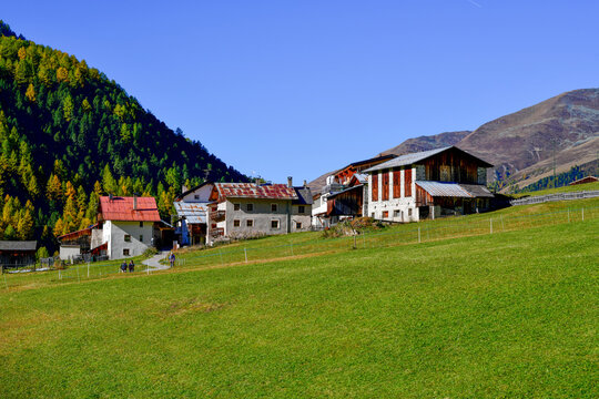 Blick &uuml;ber alpine Bergwiesen auf den kleinen Weiler Melag im herbstlichen Langtauferer Tal in S&uuml;dtirol
