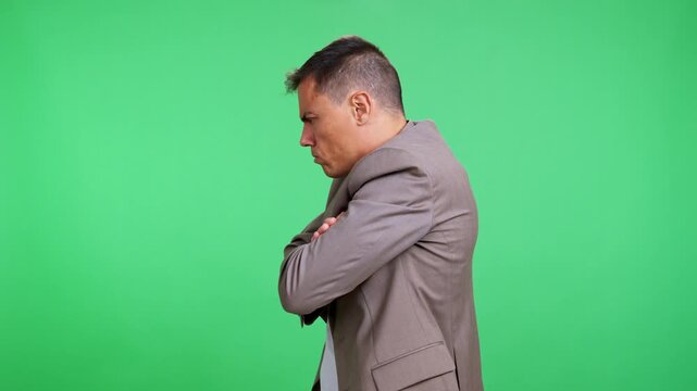 Angry stubborn businessman crossing his arms on green screen