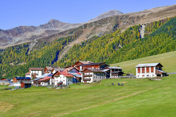 Blick über alpine Bergwiesen auf den kleinen Weiler Melag im herbstlichen Langtauferer Tal in Südtirol © Ilhan Balta