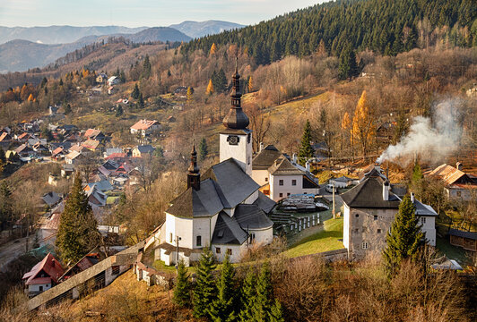 Spania Dolina with historic church, hillside houses, forested slopes, and soft autumn light, Slovakia.