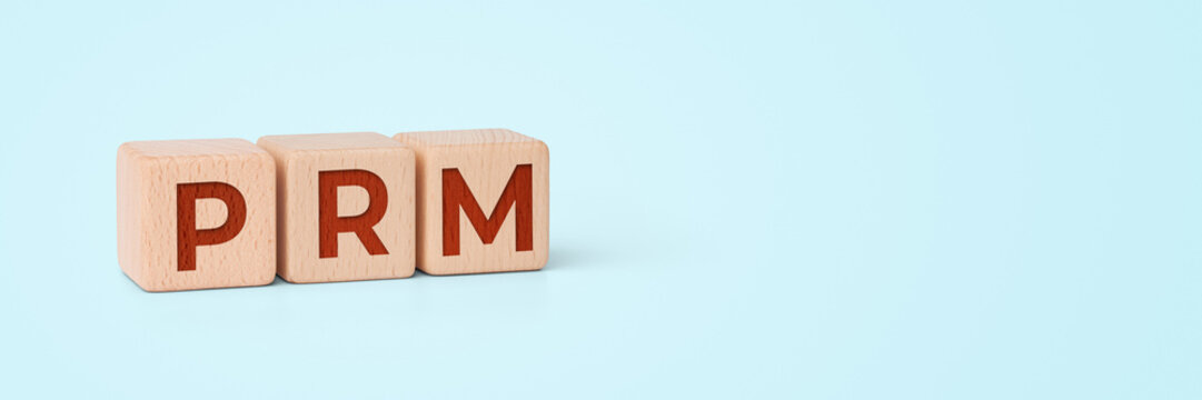 Wooden cubes with PRM letters on banner, public relations concept
