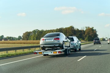 Professional tow truck hauling car safely © AlexGo