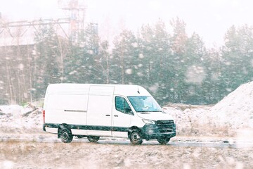 Delivery van on cold winter day road © AlexGo