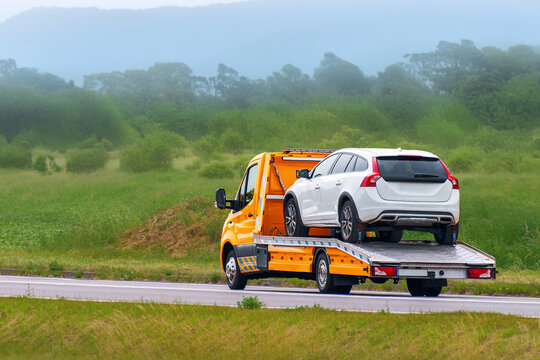Heavy duty wrecker transporting a car on a flatbed