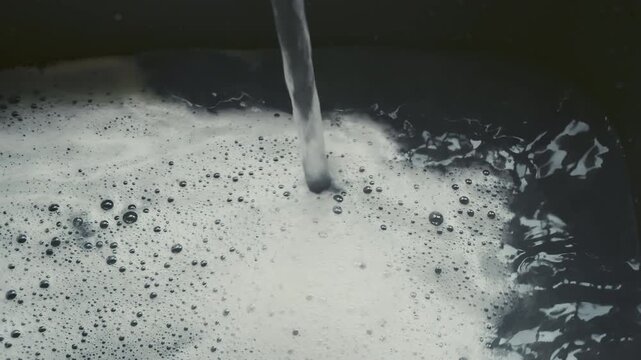 Water running into soapy water 8X slow motion stock footage