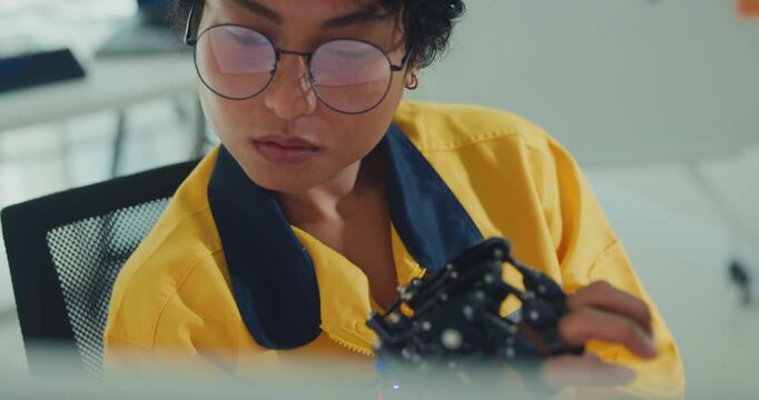 Close-up young Black female engineer coding AI robot arm in modern laboratory. Robotics, artificial intelligence, technology, stem, future, innovation, diversity, automation, machine learning concept.