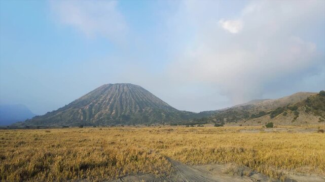 Beautiful 4K landscape of Mount Batok and smoking Mount Bromo in East Java, Indonesia.
