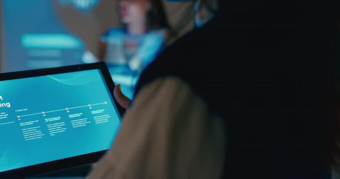 Close up group Asian businesspeople work together leads business meeting uses presentation TV with profit sale statistics in office night. Financial generation z team brainstorm on e-Commerce project.