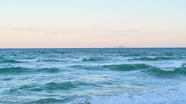 pastel sunset over ocean waves in tropical seascape
