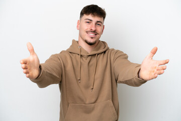 Fototapeta premium Young caucasian handsome man isolated on white background presenting and inviting to come with hand