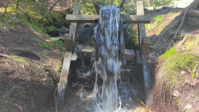 Ancient watermill wheel rotating, renewable hydro energy concept, slow motion capable