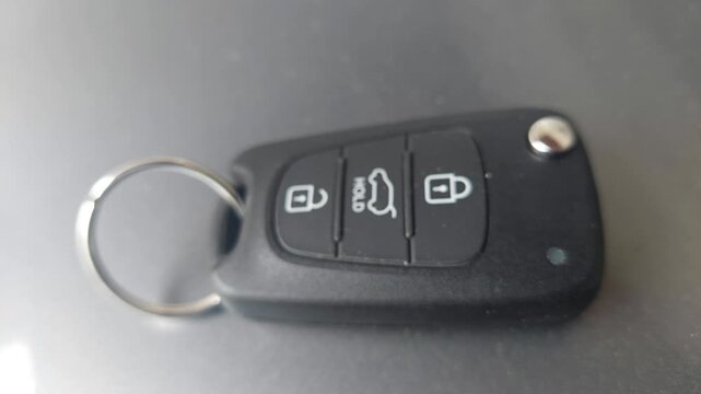 Close-up of a black modern car key fob with lock and unlock buttons