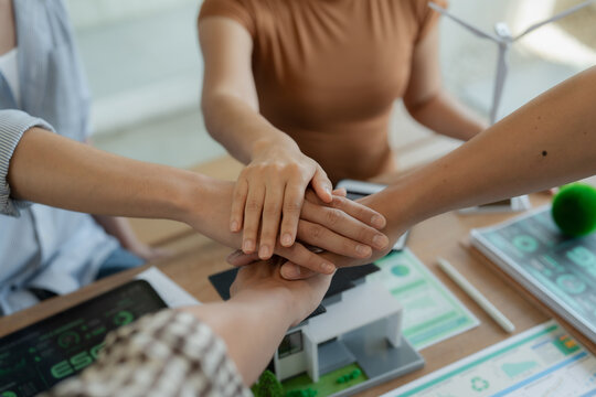 A close-up image of a group of business leaders shaking hands after completing a workshop on ESG strategic commitments and the Sustainable Development Goals report.