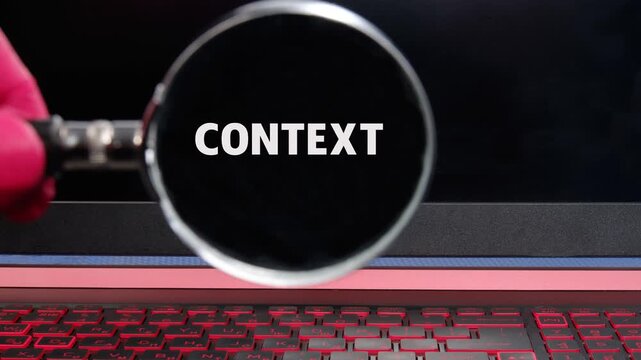 A hand holds a magnifying glass over a dark display, slowly clarifying the word context from an indistinct shape to sharp white text, revealing meaning