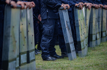 Fototapeta premium Riot police control the crowd practice and review on the grass field.