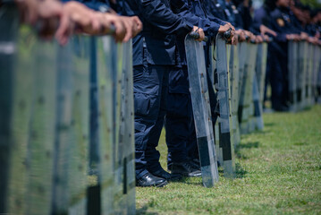 Fototapeta premium Riot police control the crowd practice and review on the grass field.