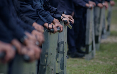 Fototapeta premium Riot police control the crowd practice and review on the grass field.