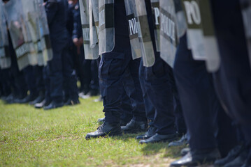 Fototapeta premium Riot police control the crowd practice and review on the grass field.
