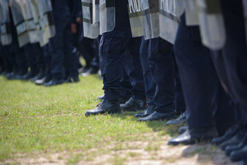 Fototapeta premium Riot police control the crowd practice and review on the grass field.