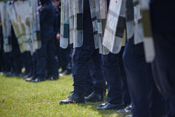 Fototapeta premium Riot police control the crowd practice and review on the grass field.