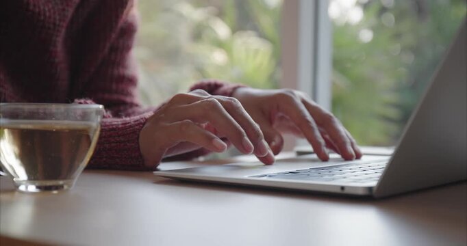 Hand of Asian woman using laptop, Asia business typing work on computer at home