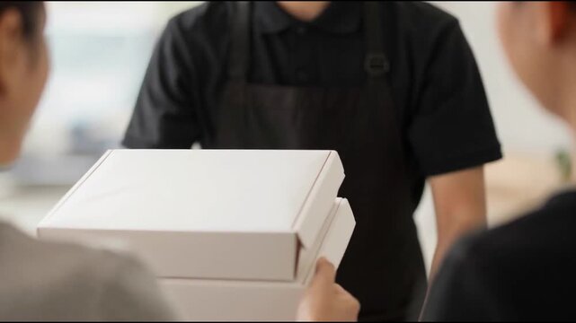 Two boxes with fast food being carried by delivery man in uniform for one of clients