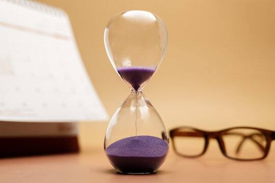 Hourglass with reading glasses and calendar, senior lifestyle, aging vision