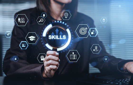 Business person holding magnifying glass with skills icons aroun
