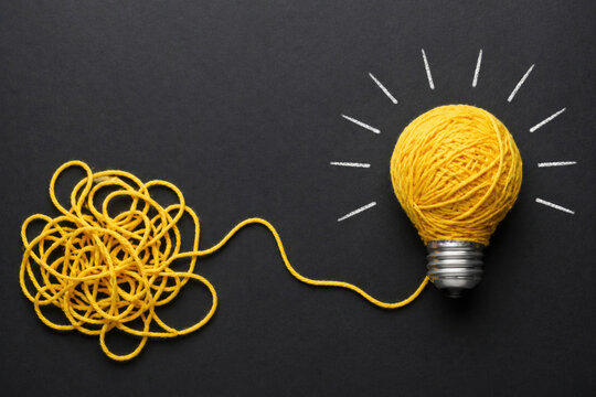 The yellow thread forms a light bulb on a black background.