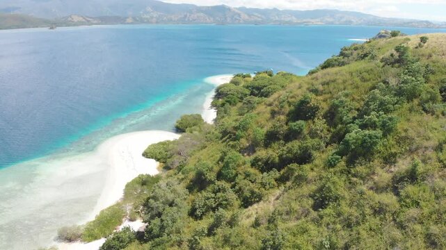 Panoramic aerial view of the 17 Islands Marine Park near Riung, Flores, Indonesia, featuring turquoise coral reefs, tropical islets, and deep blue ocean under a bright sky
