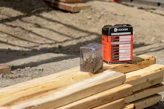 La Tuque, Quebec, 11 May 2026 : Duchesne nail range box and a container of screws sit on wooden planks at a construction site.