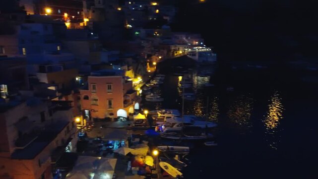 Night drone footage of Procida harbor and colorful island